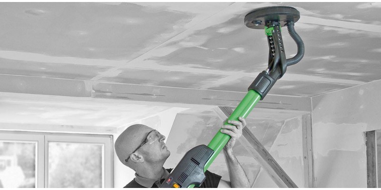 man using long reach electric sander on ceiling